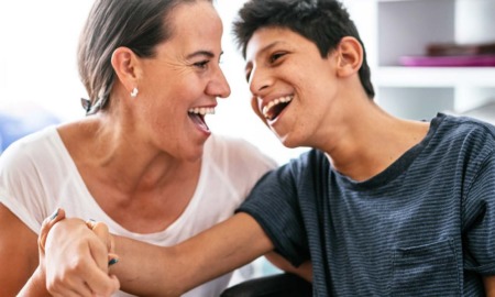 2022 KIDS COUNT Data Book: mentally challenged boy laughing with guardian at table