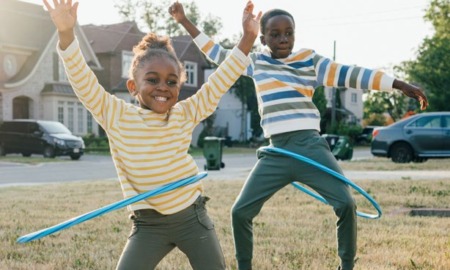 2024 KIDS COUNT data book: two black children hula-hooping happily