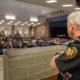 school police debate: school security guard looks out over cafeteria full of students