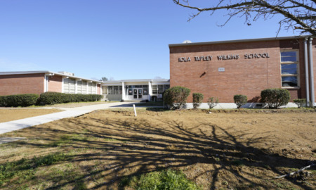 Mississippi afterschool programming: Red brick buildings under clear blue sky with school name signage