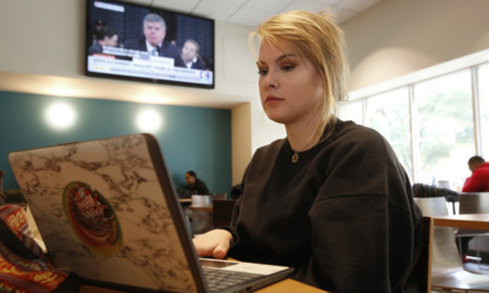 Online SAT: A person with blonde hair sits next to a laptop