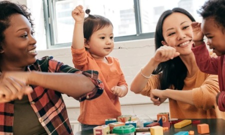 Children's education, arts, community grants: two women and two children happily playing with block toys