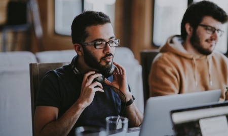 diversity and equity in U.S. apprenticeships: young ethnic man with glasses putting on headphones at computer