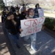 Denver school shooting suspect dead; parents push security: people marching down sidewalk with "Stop gun violence" sign