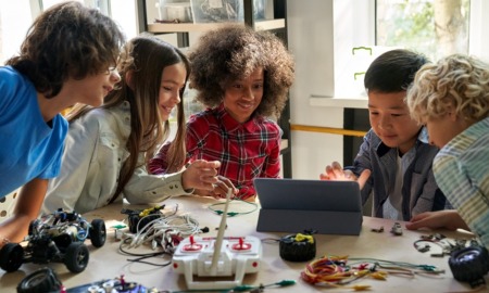 STEM education program grants: diverse children work on STEM project at table