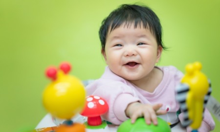 2024 kids count data book, child well-being, early childhood health grants: happy baby of Asian descent playing