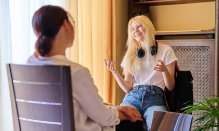 youth mentoring for rural, at-risk, justice-involved youth: happy teenage female with light hair and headphones around neck in therapy session