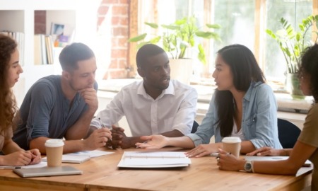 youth inequality grants: diverse employees team discussing project at meeting,