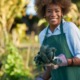 community food access: african american woman holding freshly picked kale from comnunal community garden posing for portrait