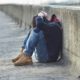 runaway and homeless youth grants: young person sitting with head in hands on side of a street