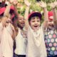 youth summer camp and learning program award: happy children raising hands outside