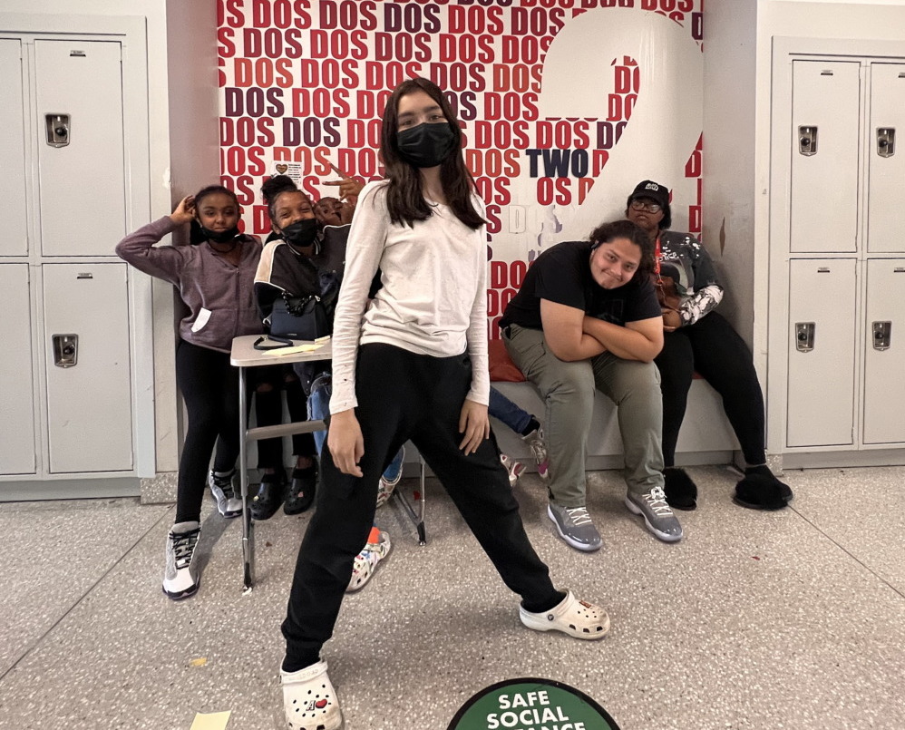 COVID recovery - Several young people stand and sit in front of white lockers