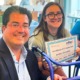 Rachel Solomon and J.D. LaRock: girl with long brown hair and glasses smiles while holding certificate next to man in glasses