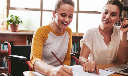 Lessons from tutoring revolution in public education: white woman with brown hair helping white, lighter-haied female student on schoolwork