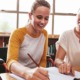 Lessons from tutoring revolution in public education: white woman with brown hair helping white, lighter-haied female student on schoolwork