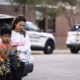 teacher shot by 6-year old 'red flag' for country: mother and frightened child stand outside next to police cars