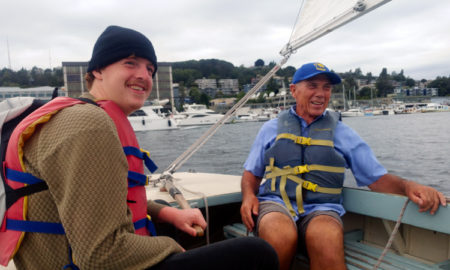 homelessness: 2 men with life jackets on in boat, smiling.