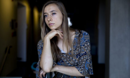 host home: Young woman with long light brown hair looks to left.