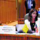 legislature: Woman in white blazer sits at large wooden desk with name card in front of her that says Rep. Kelly K. Fajardo R-Valencia-7