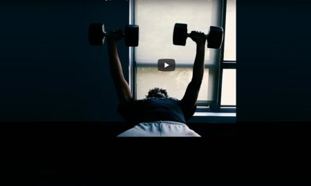 Foster Youth & Higher Education: Man exercising on back raising small dumbells.