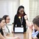 youth organizations step up to fill gap in classroom civic discourse: youth group led by young black female student discussing at table