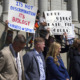 Utah Transgender Sports: Several adults in business attire stand in front of adult protestors holding signs