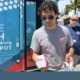 Youth drog overdoses: Young man wearing sunglasses stands with older amn in parking lot next to blue mobile medical vehicle