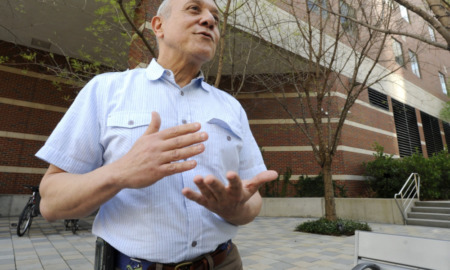 Transgender law Alabama: Older, balding man in light blue shirt stands speaking and gesturing with hands in front of red brick building