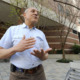 Transgender law Alabama: Older, balding man in light blue shirt stands speaking and gesturing with hands in front of red brick building