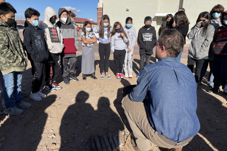 Climate change education: children stand outside with a man in a blue shirt