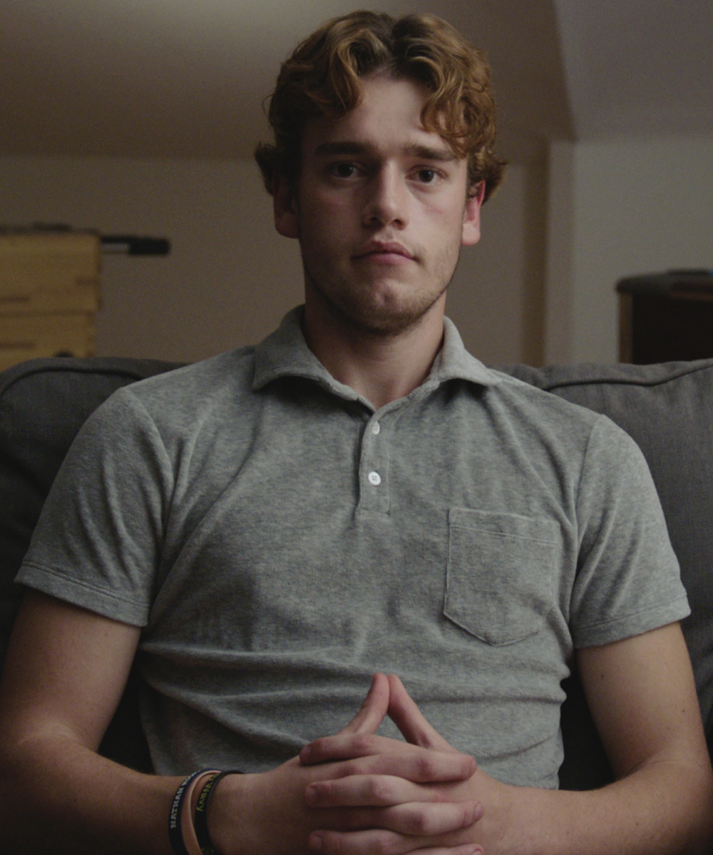 Mental Illness: Man with red, curly hair wearing gray polo shirt sits with hands clasped in lap