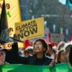 Climate change protest: Young people in street carrying protest signs about climate change