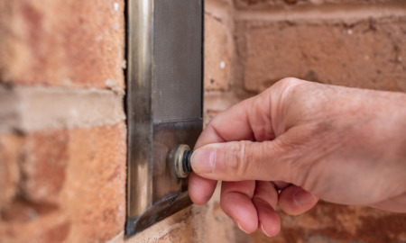 No warrant entry: Hand pressing culver doorbell set in red brick wall