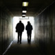 Sex Offender Registry: Silhouette of two people walking away in a dark tunnel toward a lighted exit