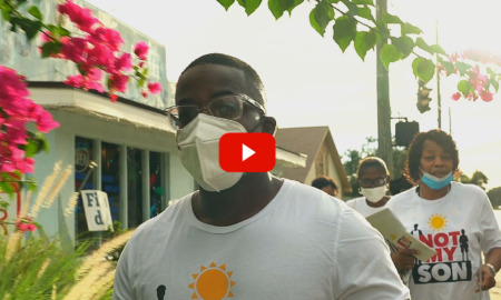 Gun Violence: Group of Black adults wearing masks with "Not My Don" t-shirts walk along city sidewalk