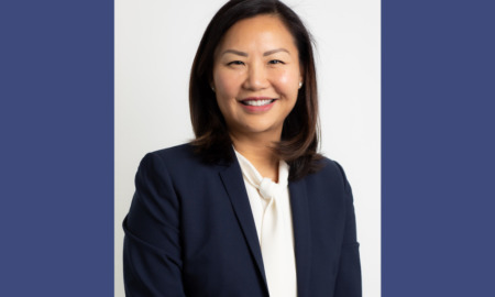 Interview: JooYeun Chang woman with long dark hair in navy suit and white blouse smiles into camera.