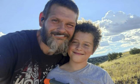 Child Death Weldare Distody: Man with brown hair ans frating beard stands close to young boy with brown hair both smiling into camera