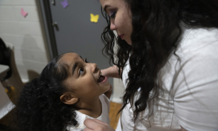 Reunification incarcerated parents: Close up of woman holding young girl both looking into each other's faces and smiling