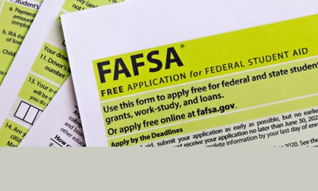 FAFSA paper forms in black ink with lime green boxed highlights on white paper