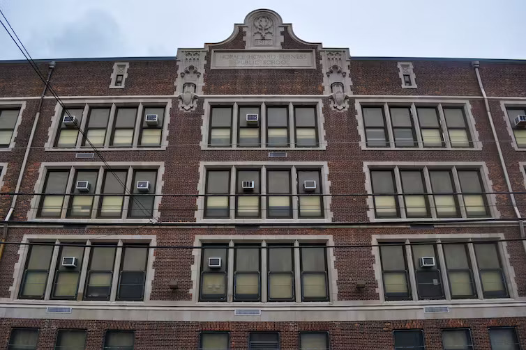 Tax Cuts cost schools: Multi-story, large, traditional, red brick building with ornate white trim