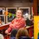 Georgia summer camp for disabled youth: A woman with tied-back brown hair wearing a red sweatshirt dances with a group of children dressed in casual clothing.