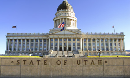 Utah child custody law: Utah state capitol — multi-storied, white, traditional architecture building with large, dark dome and American flag in front.