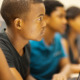 Segregated academies: Four Black students sit in a eow ar laptops