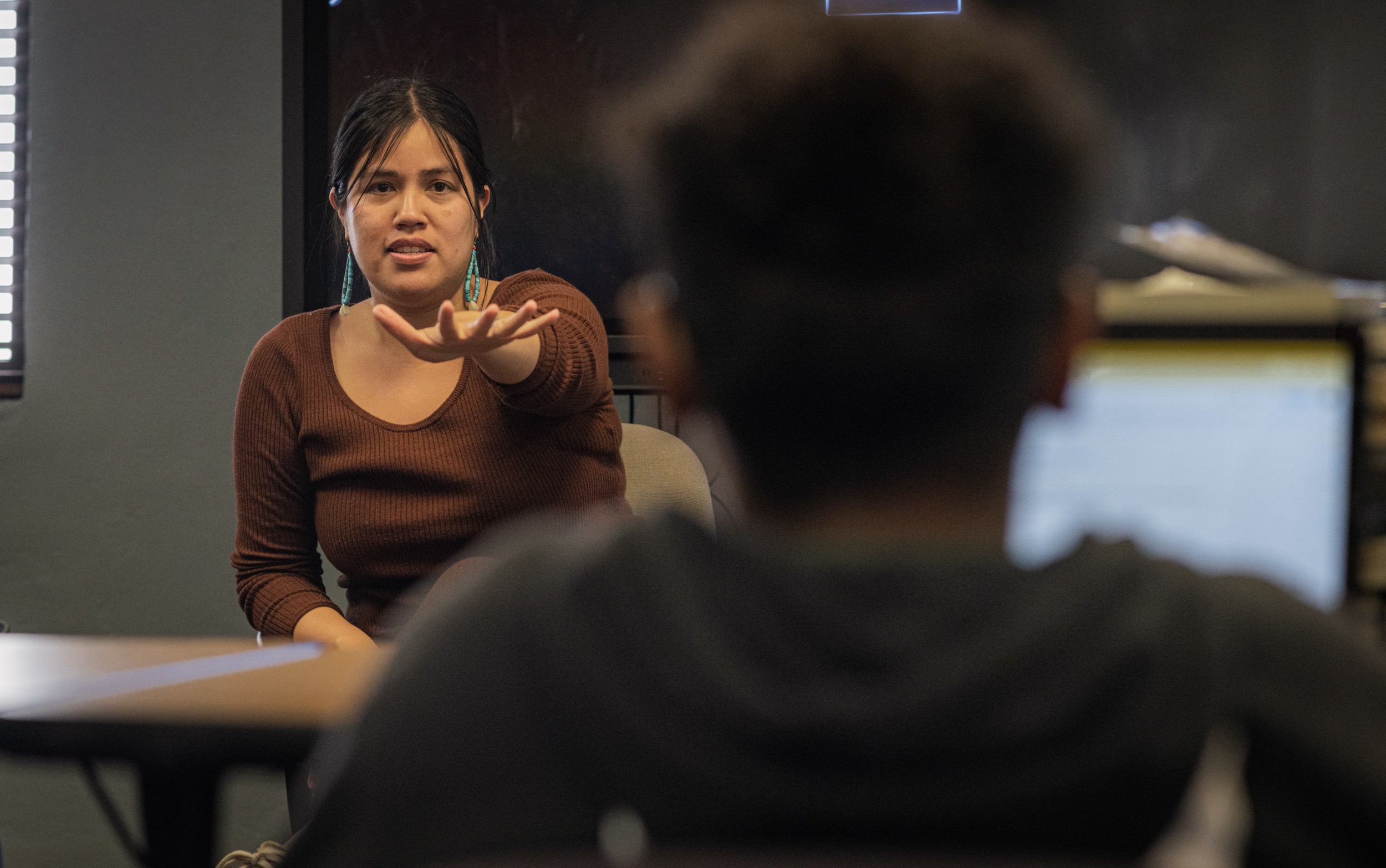 Native American Charter School; Woman sits with several teens having a discussion