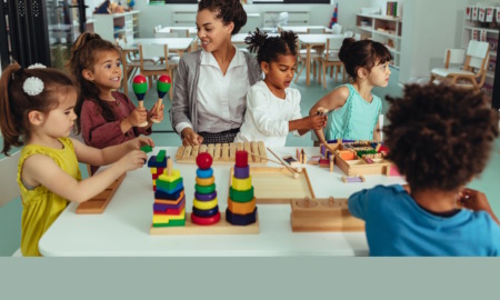 Childcare: Mixed ethnic group of preschoolers sit at activity table with female teacher