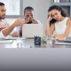 School boards: Group of multi-ethnic adults in business clothes sitting around table talking with expressions of disagreement