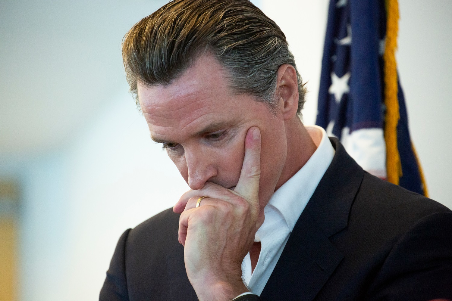 Newsom's aboutface raises homelessness risks for California's oldest foster care youth: white man in suit with head in hand looking down