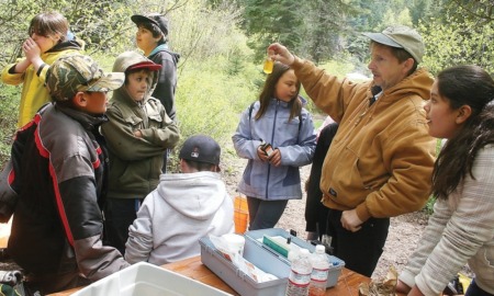 Northwest Native-American community grants: group of youths learning about environment outdoors from educator