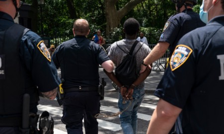 NYPD wrongly arresting black kids on Halloween: group of NYPD officers walking an arrested black youth across the street