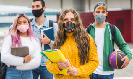 Youth Funder relationships: 4 teens wearing masks holding books and a basketball in OST gym program